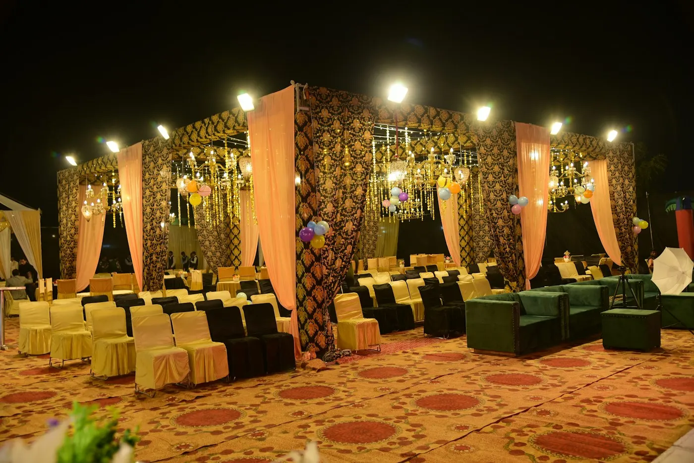 Lit-up banquet venue set with sofas and drapes